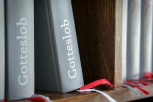 Gotteslob hymnals on a shelf